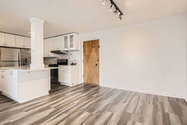 kitchen featuring decorative backsplash, stainless steel appliances, sink, light hardwood / wood-style flooring, and white cabinetry