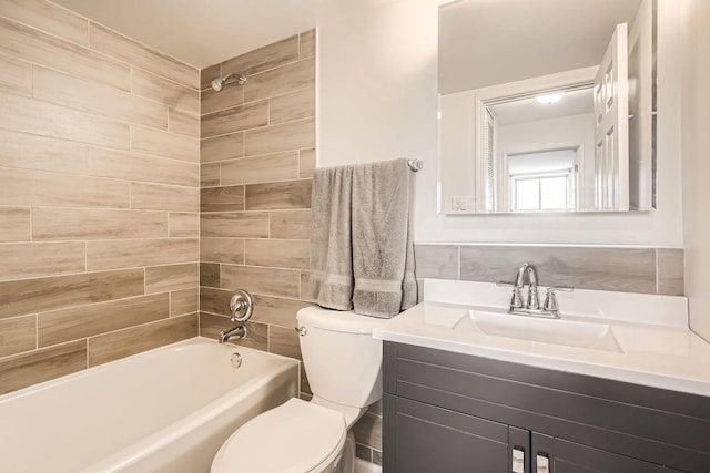 full bathroom with toilet, vanity, and tiled shower / bath