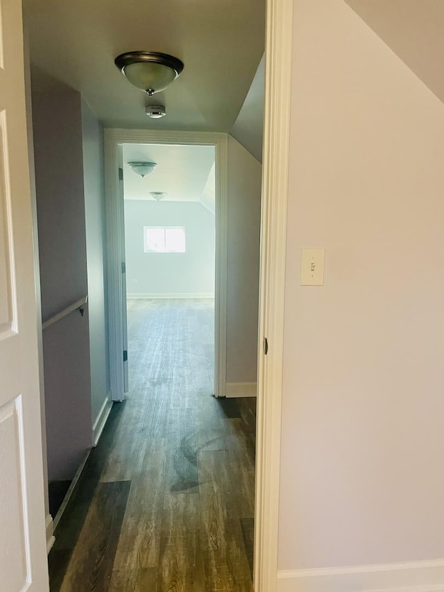 hallway featuring dark wood-type flooring and lofted ceiling