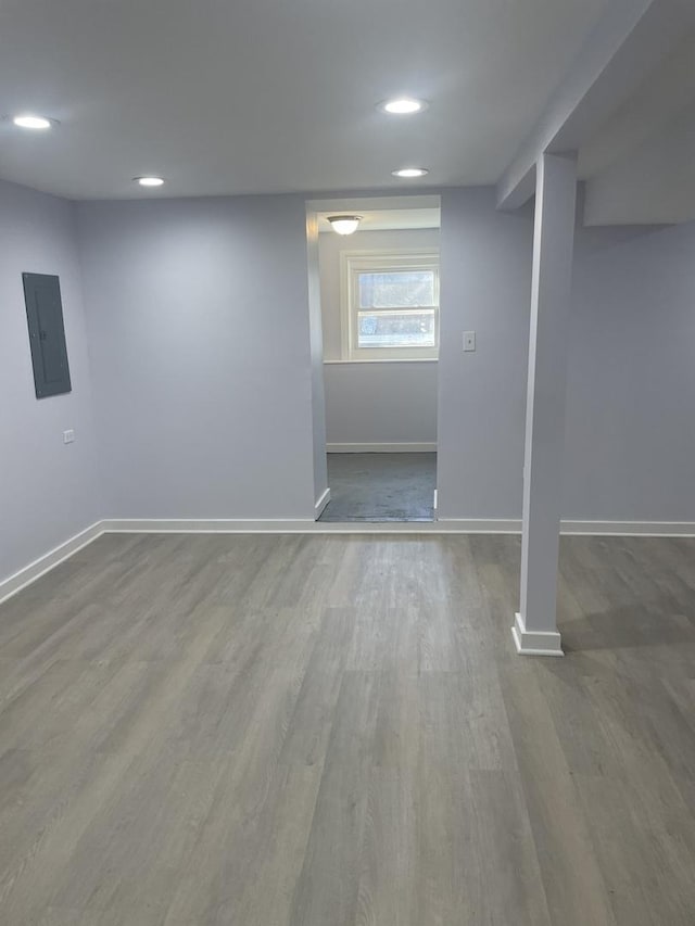 basement featuring hardwood / wood-style flooring and electric panel