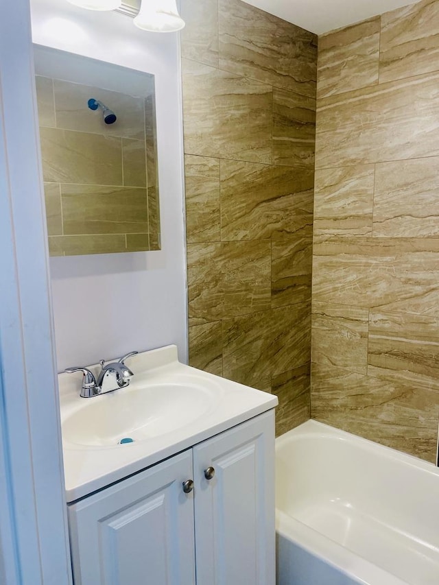 bathroom featuring vanity and tiled shower / bath