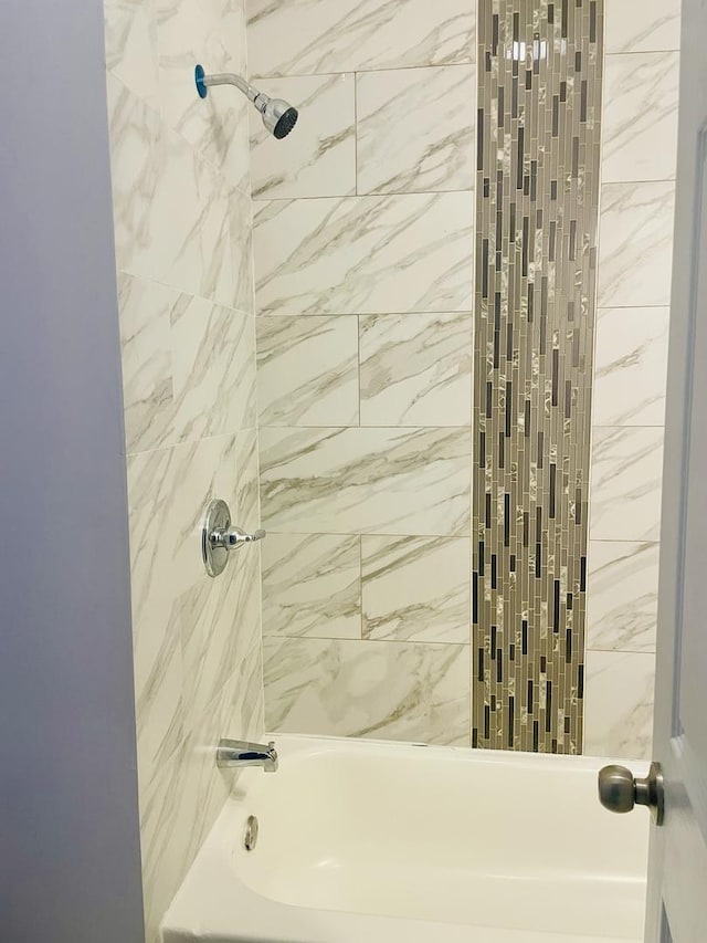 bathroom featuring tiled shower / bath