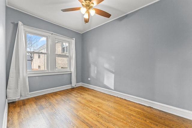 empty room with ceiling fan, wood-type flooring, and ornamental molding