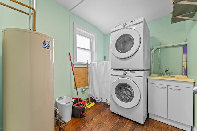 washroom with cabinets, sink, water heater, stacked washer / drying machine, and dark hardwood / wood-style flooring