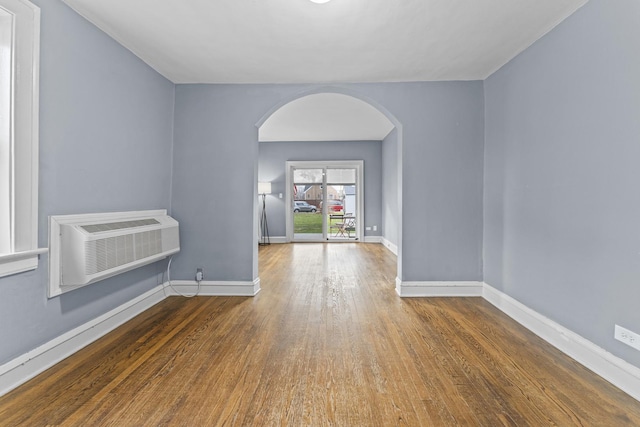 unfurnished room featuring a wall mounted AC and wood-type flooring