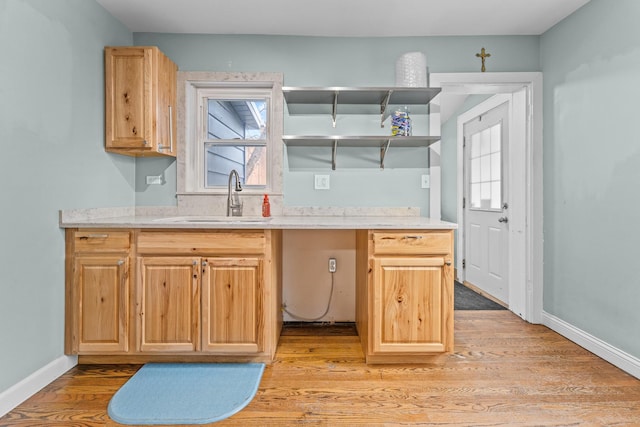 kitchen with light brown cabinets, light wood-type flooring, and sink