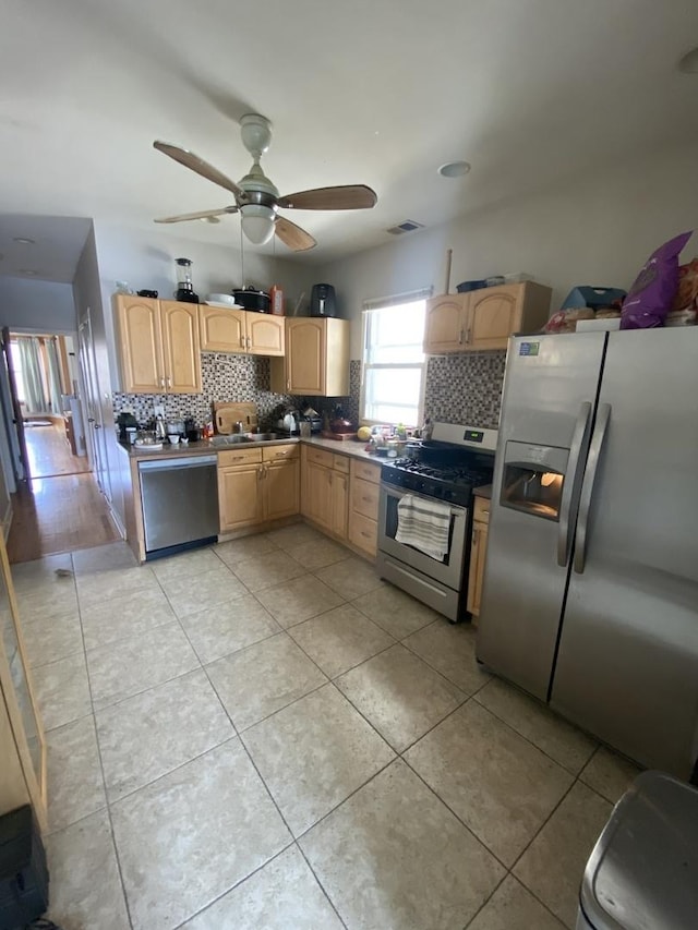 kitchen with appliances with stainless steel finishes, backsplash, ceiling fan, sink, and light brown cabinets