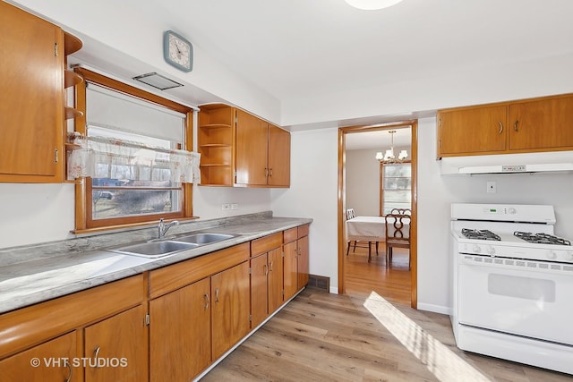 kitchen featuring white range with gas cooktop, sink, light wood-type flooring, and a notable chandelier