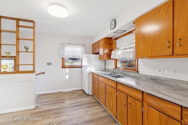 kitchen featuring sink, white fridge, and light hardwood / wood-style floors