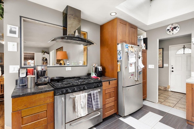 kitchen with exhaust hood, dark tile patterned flooring, and appliances with stainless steel finishes