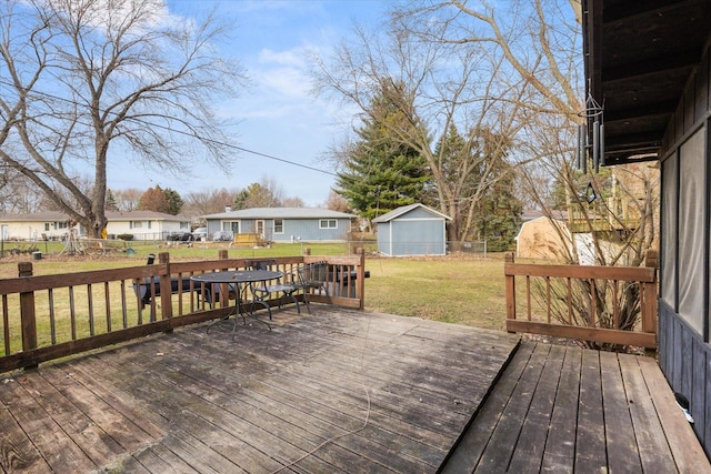 wooden deck with a lawn and a storage unit