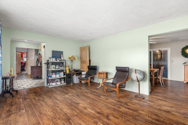 sitting room featuring dark hardwood / wood-style flooring and a textured ceiling