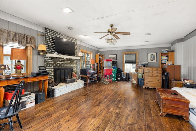 living room with hardwood / wood-style flooring, a brick fireplace, ceiling fan, and ornamental molding