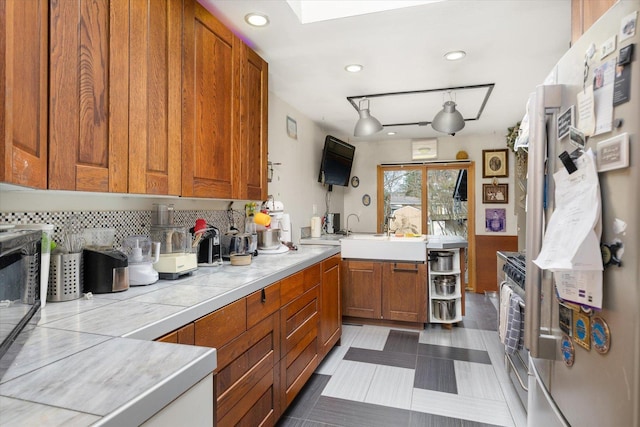 kitchen featuring tasteful backsplash, tile counters, sink, and stainless steel appliances