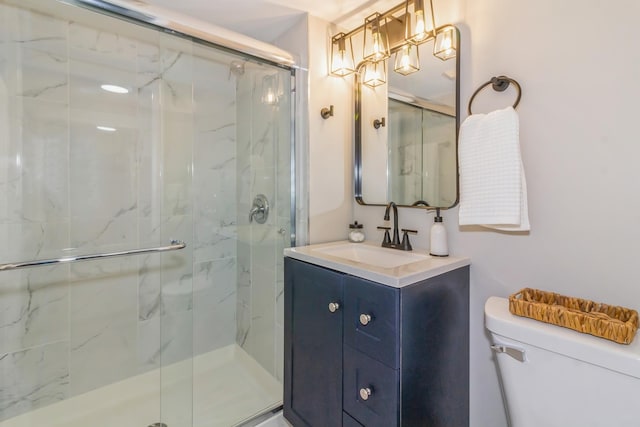 bathroom featuring toilet, an enclosed shower, and vanity