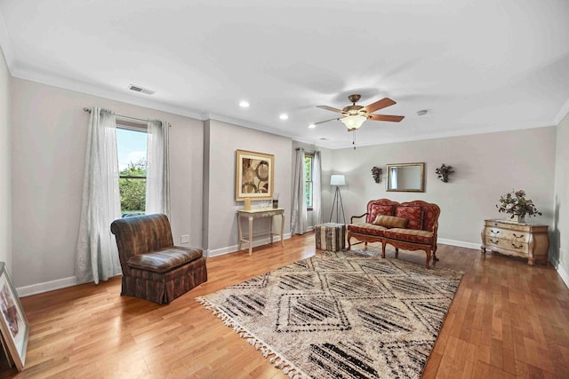 sitting room with crown molding, hardwood / wood-style floors, and ceiling fan