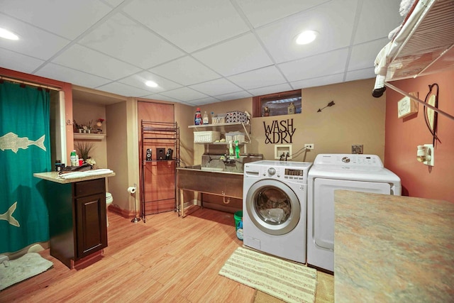 clothes washing area with light wood-type flooring and independent washer and dryer