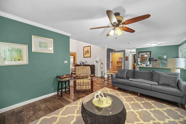 living room featuring hardwood / wood-style floors, ceiling fan, crown molding, and a textured ceiling