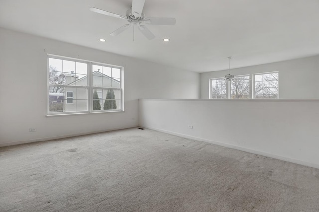 empty room featuring ceiling fan and carpet