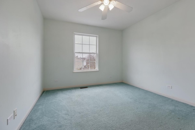 spare room with ceiling fan and carpet