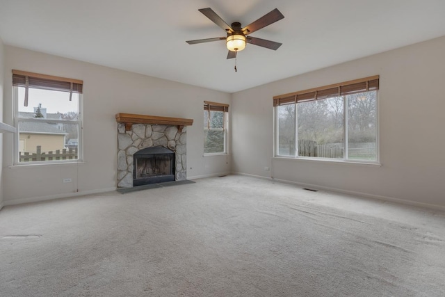 unfurnished living room with a fireplace, carpet floors, and a healthy amount of sunlight