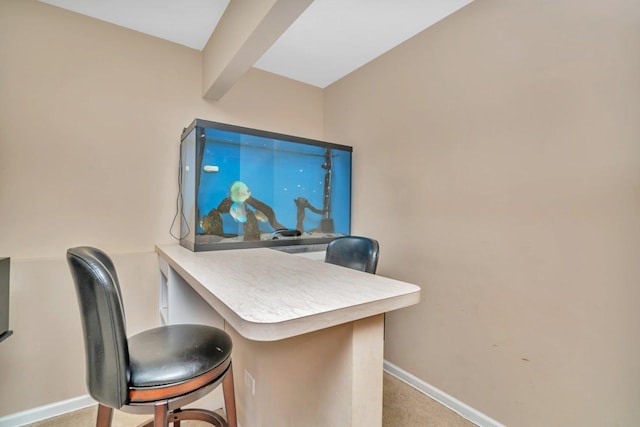 home office with beam ceiling and light colored carpet