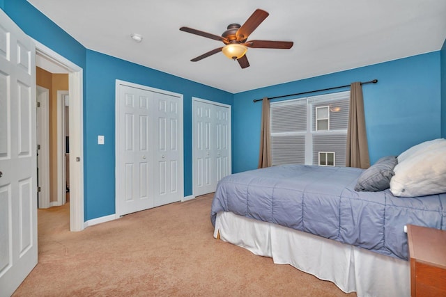 carpeted bedroom featuring two closets and ceiling fan