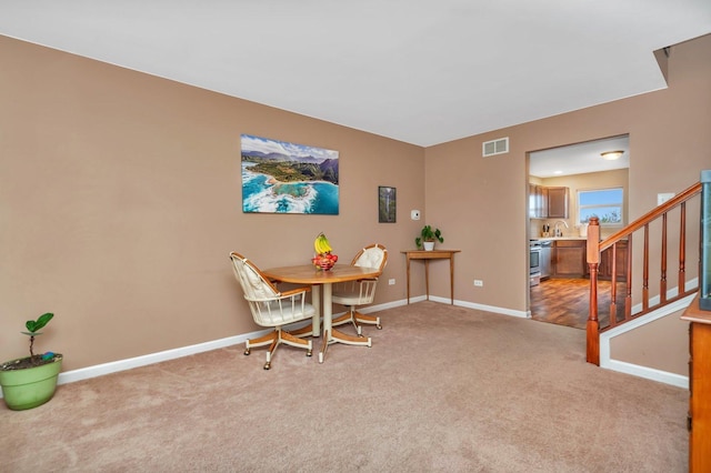 carpeted dining space featuring sink