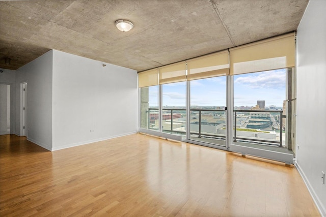 empty room with hardwood / wood-style floors and a healthy amount of sunlight