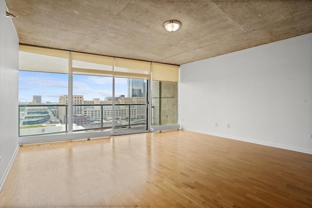 unfurnished room featuring hardwood / wood-style floors and floor to ceiling windows