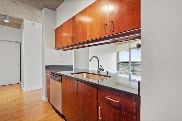 kitchen featuring stainless steel dishwasher, light hardwood / wood-style floors, sink, and dark stone counters