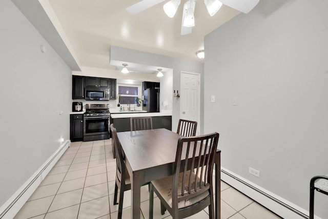 dining space with light tile patterned floors, ceiling fan, a baseboard heating unit, and sink