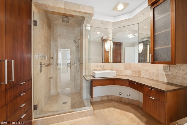 bathroom with tile patterned flooring, vanity, walk in shower, and tasteful backsplash