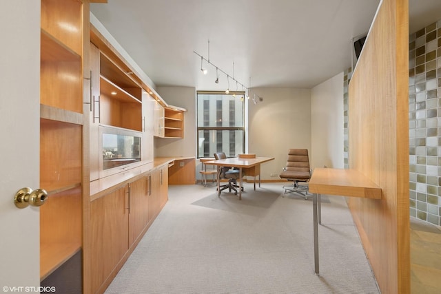 home office with light colored carpet and track lighting