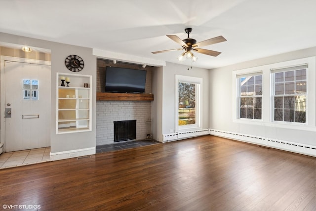 unfurnished living room with hardwood / wood-style flooring, ceiling fan, a baseboard heating unit, and a brick fireplace