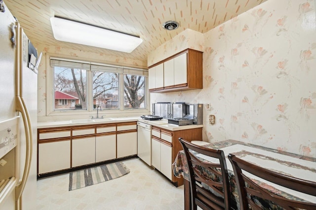 kitchen with white cabinetry, sink, and white appliances