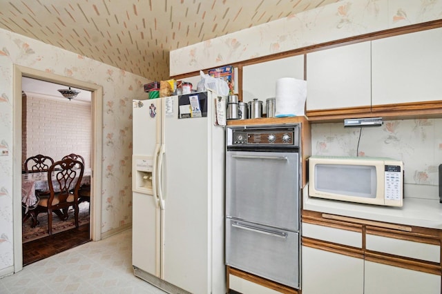 kitchen with white appliances, light hardwood / wood-style floors, and white cabinetry