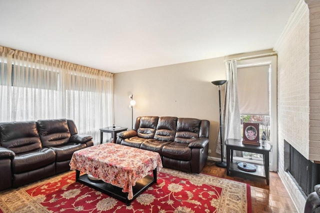 living room with plenty of natural light, parquet flooring, and a brick fireplace