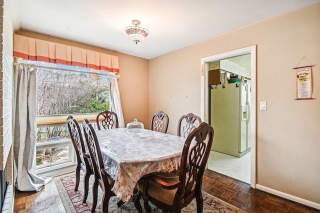 dining space featuring dark parquet floors