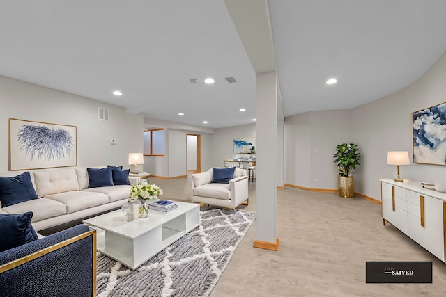 living area with baseboards, light wood-style flooring, visible vents, and recessed lighting