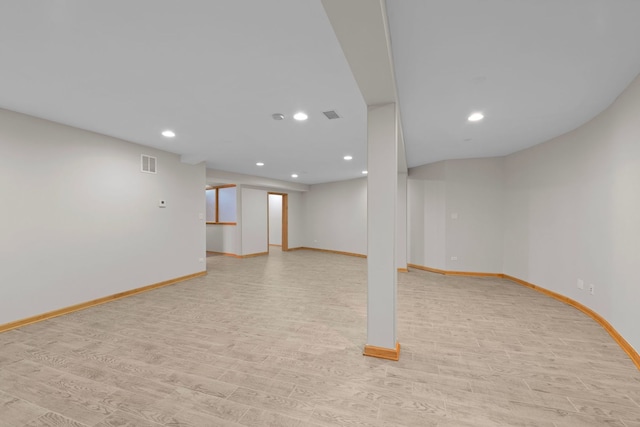 finished basement featuring recessed lighting, baseboards, visible vents, and light wood finished floors