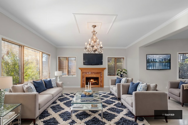 living room featuring ornamental molding, a chandelier, a fireplace, and baseboards