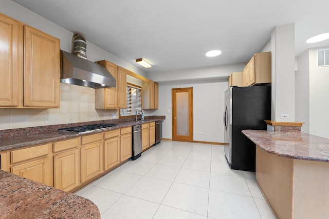 kitchen featuring light tile patterned floors, baseboards, dark stone countertops, stainless steel appliances, and a sink