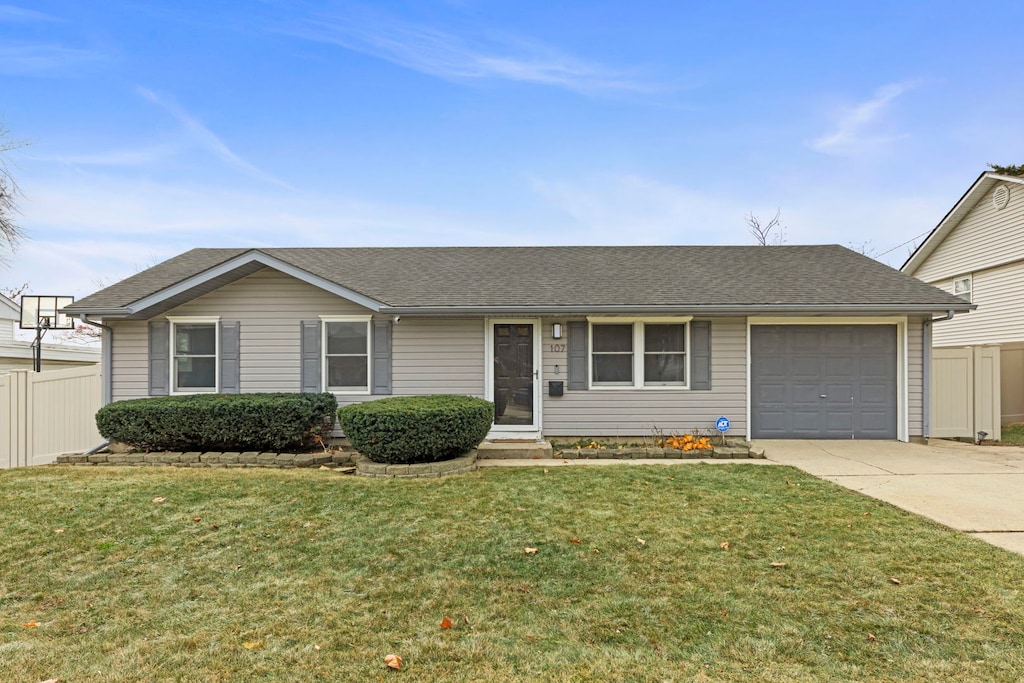 ranch-style home featuring a garage and a front lawn