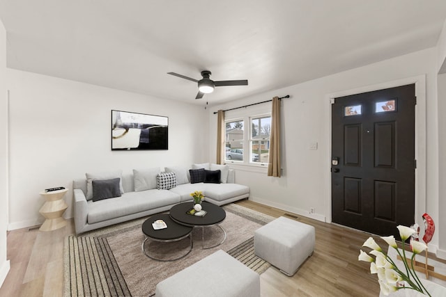 living room featuring light wood-type flooring and ceiling fan