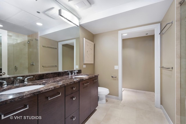 bathroom with tile patterned floors, toilet, an enclosed shower, and vanity