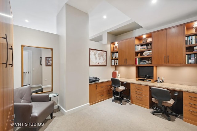 carpeted home office featuring built in desk