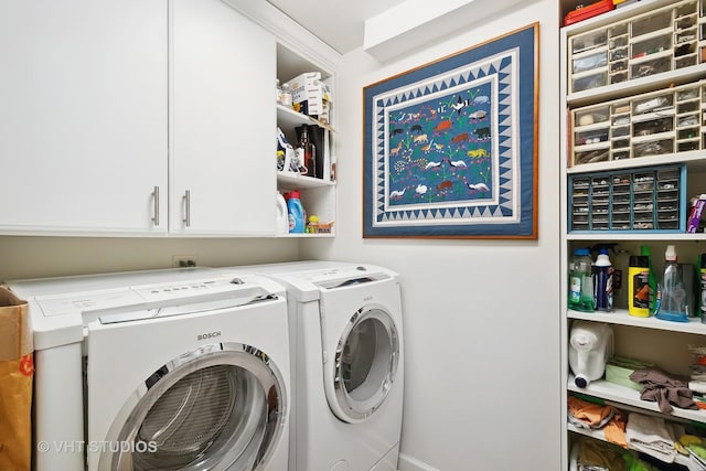 clothes washing area featuring cabinets and separate washer and dryer