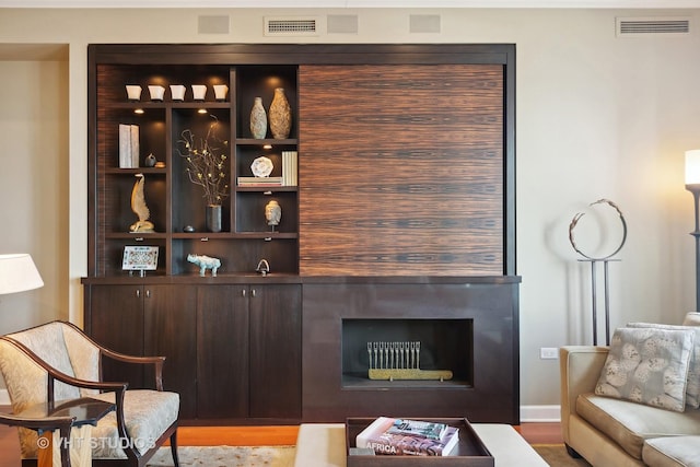 bar with dark brown cabinets and light hardwood / wood-style flooring