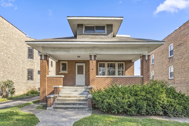 view of front of house featuring brick siding and covered porch